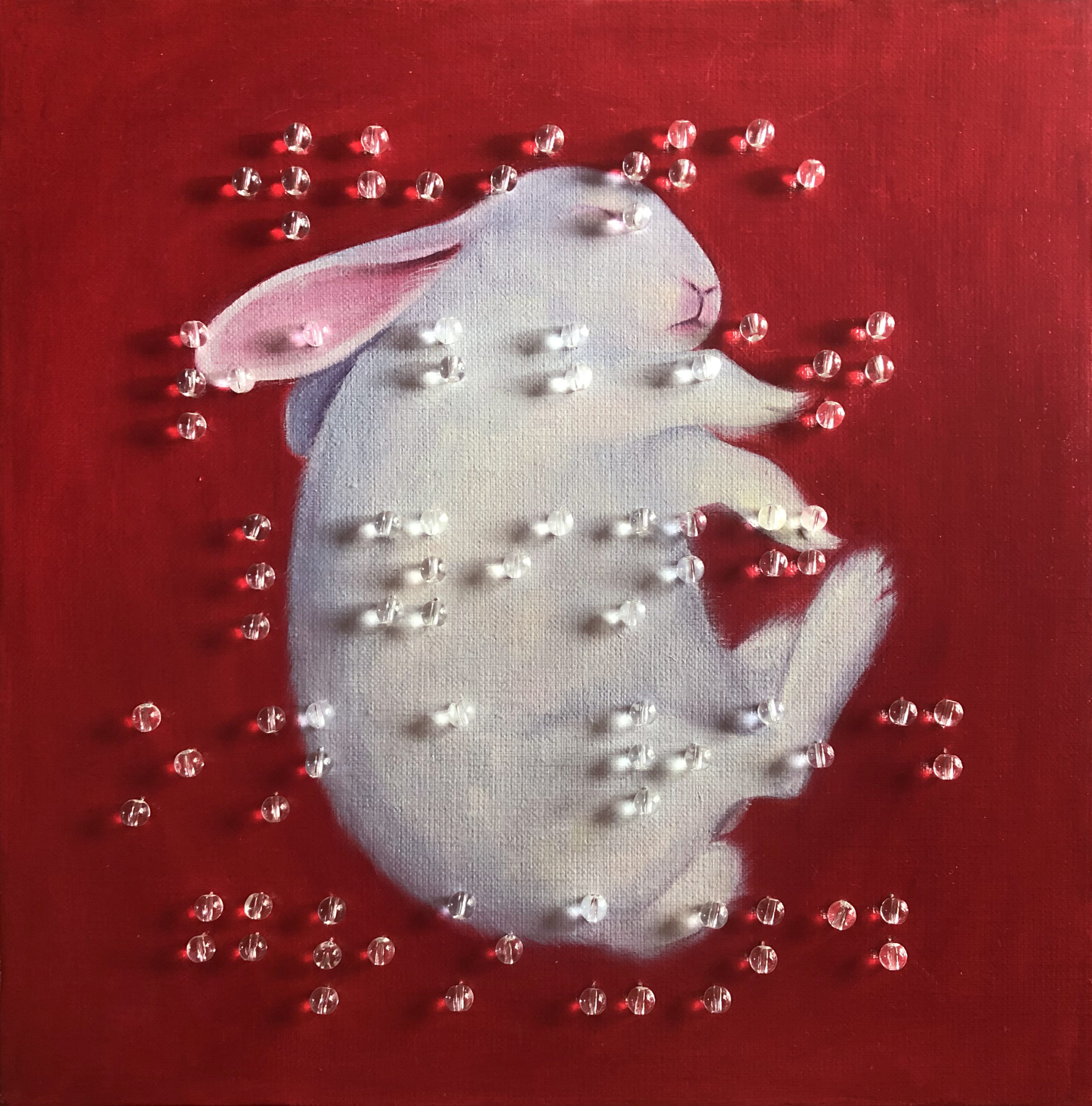 WHITE RABBIT LYING ON A RED GROUND