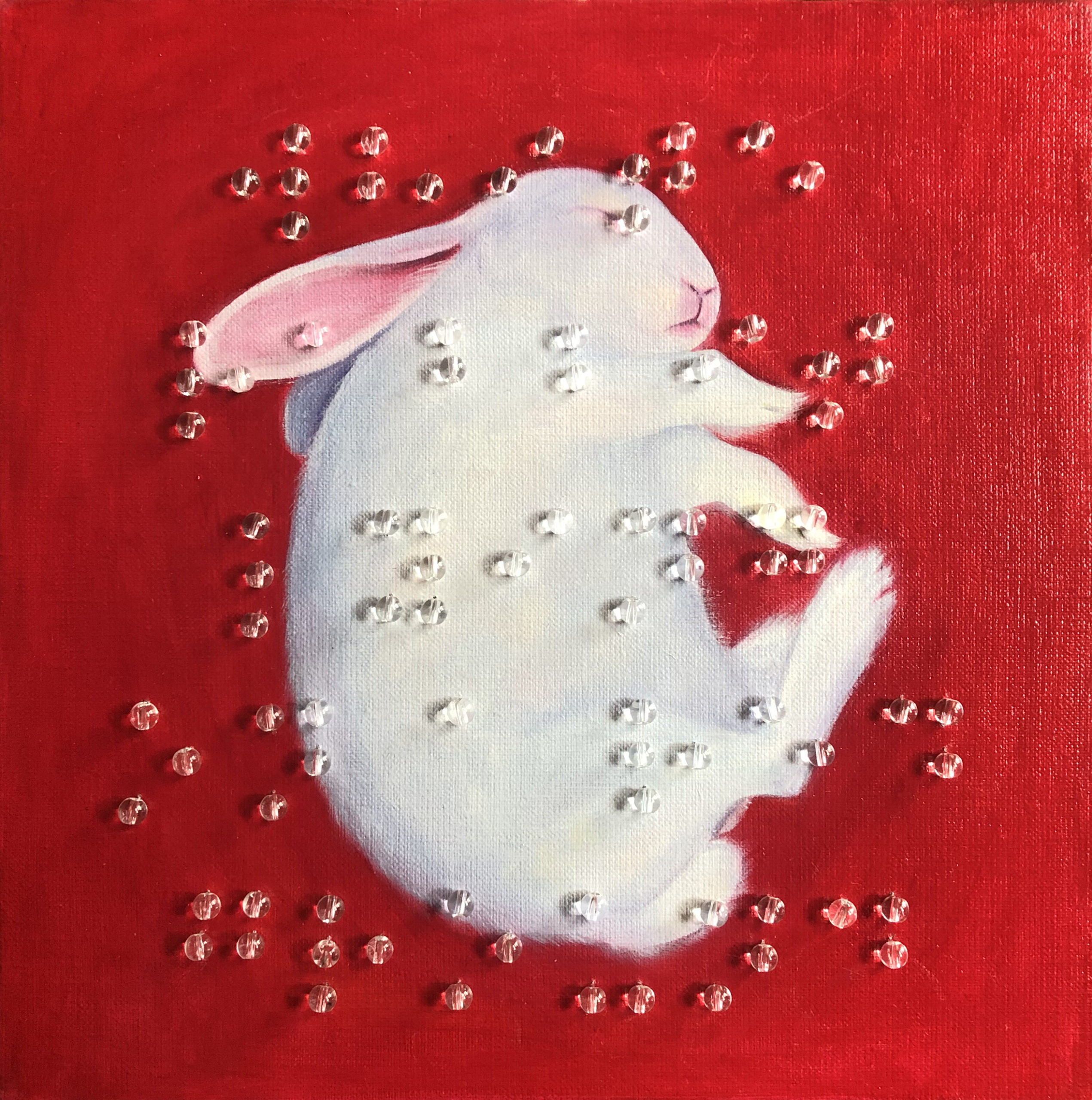 WHITE RABBIT LYING ON A RED GROUND